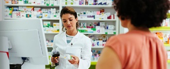 Mulher na farmácia a pagar medicamentos