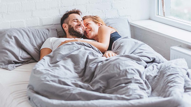 Casal na cama a sorrir