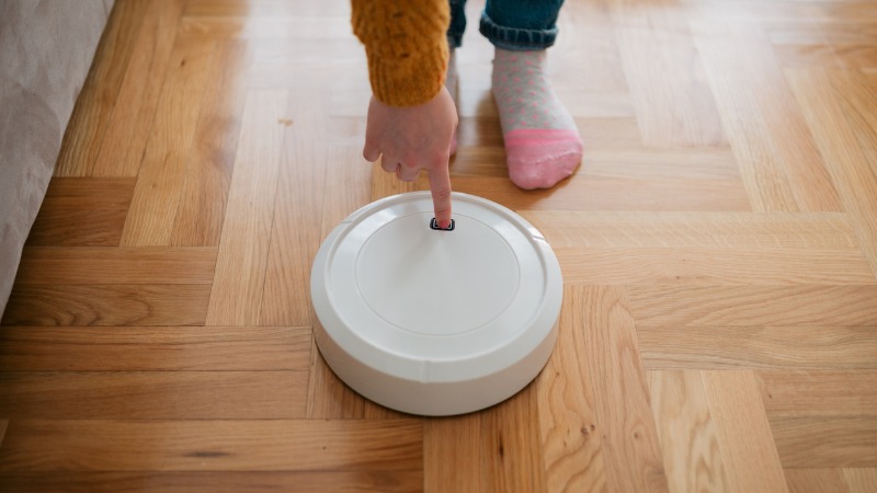 Consumidor tentar ligar aspirador robot.