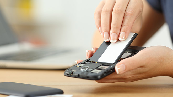 Consumidores coloca uma bateria no telemóvel.