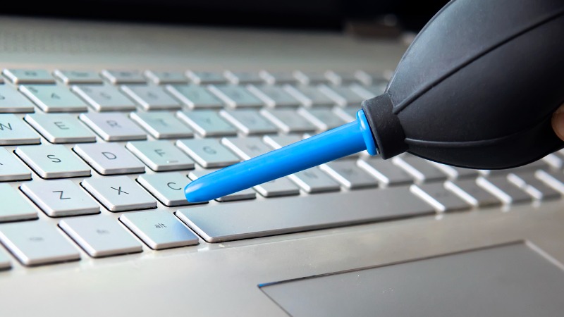 Utilizador a limpar o teclado do computador.