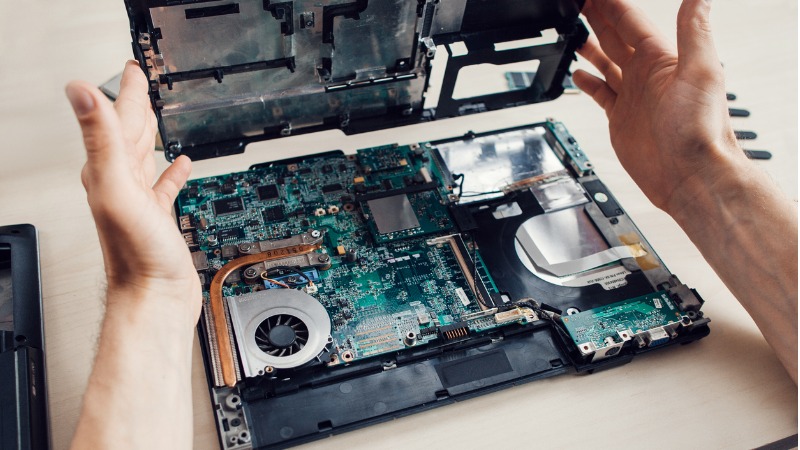 Utilizador tenta reparar a placa-mãe do portátil.