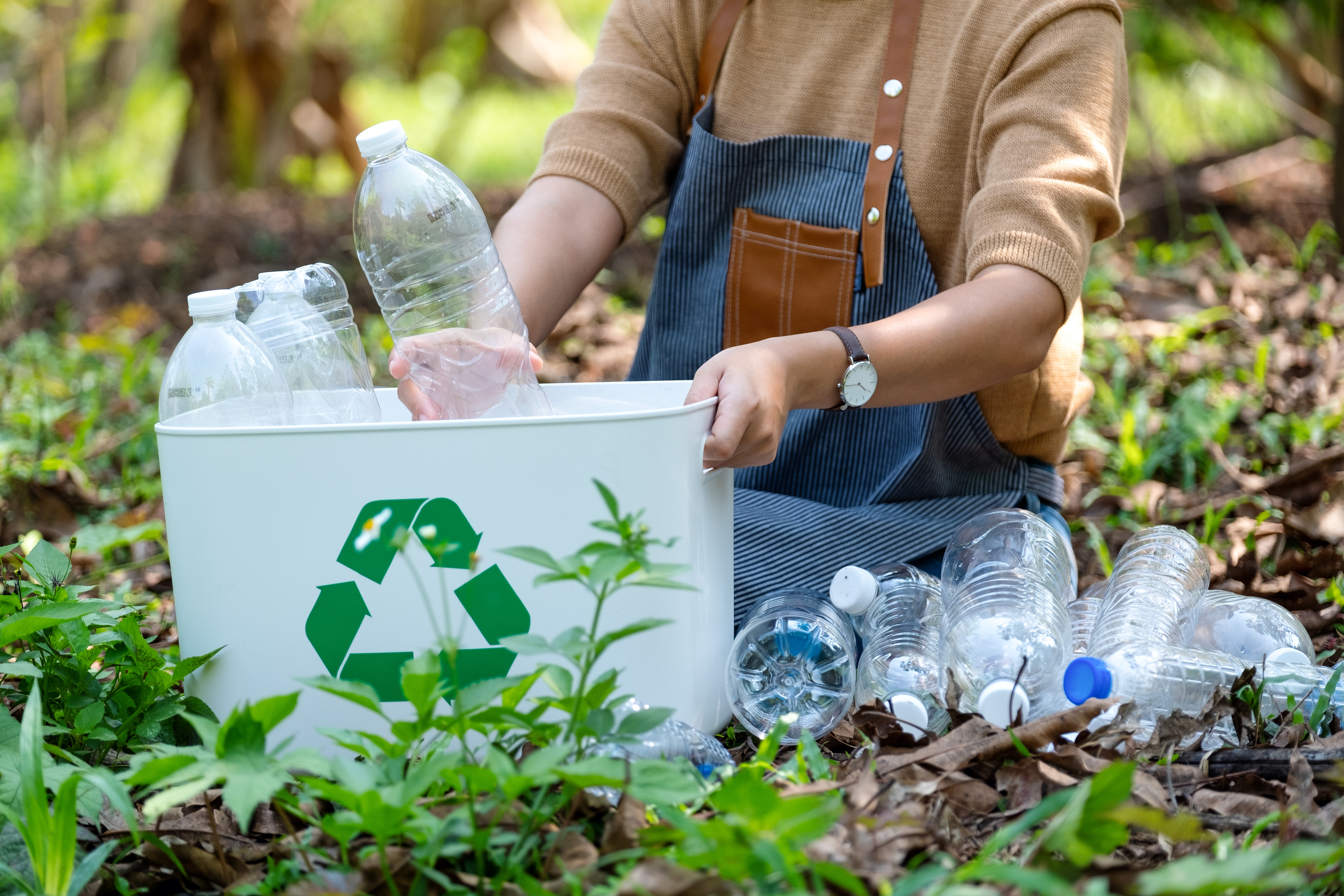 Consumidor a reciclar garrafas de plástico.