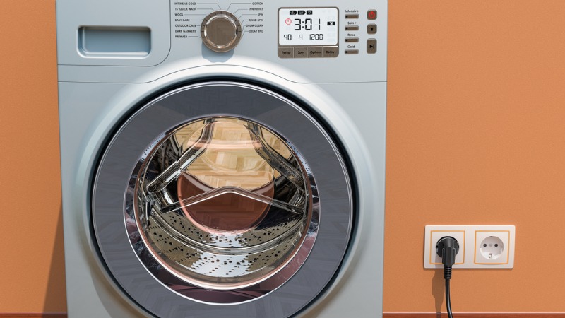 Máquina de lavar roupa ligada à tomada elétrica.