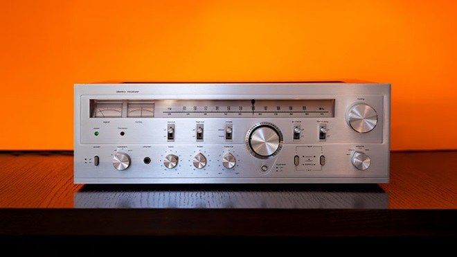 Bancada com uma aparelhagem antiga sobre uma prateleira, fundo laranja