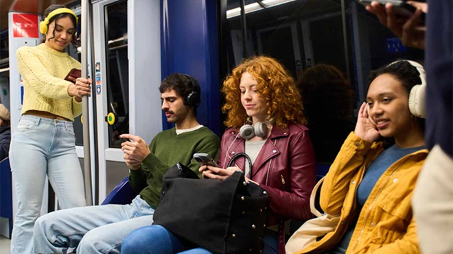 Grupo de jovens com auscultadores no metro