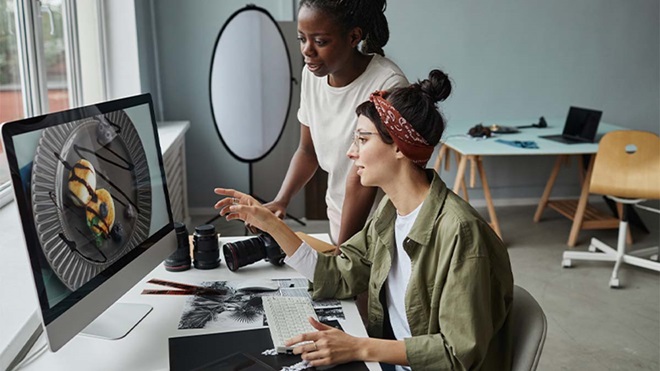 Duas mulheres a fazer edição de imagem em escritório de design