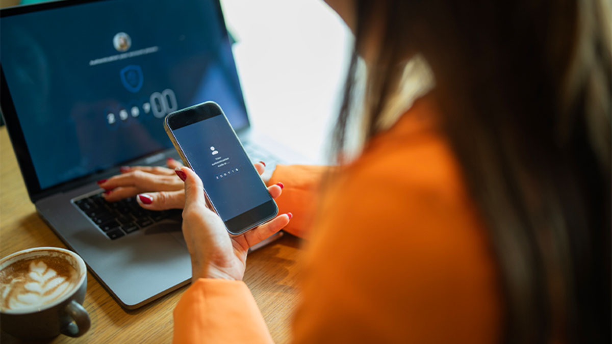 Mulher a consultar ficheiros na cloud no portátil e no telemóvel