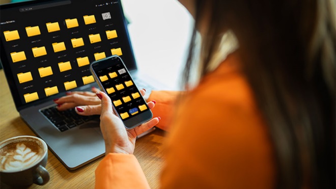 Mulher a consultar ficheiros na cloud no portátil e no telemóvel
