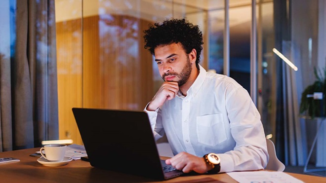Homem consulta o seu portátil