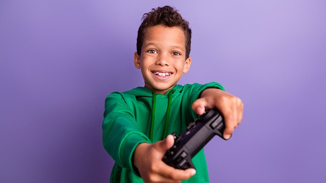 Rapaz a jogar com um comando da playstation