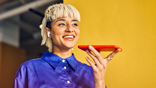 Mulher moderna a falar para um telemóvel - alusão a tradução com AI
