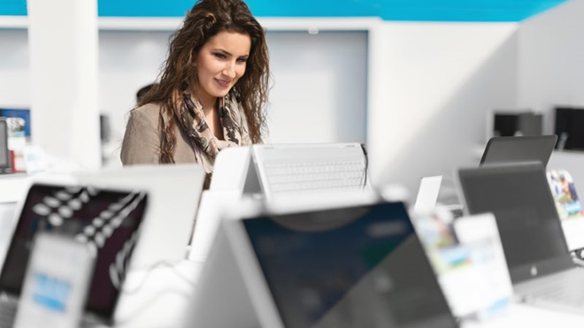 mulher vê portáteis numa loja de computadores