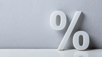 Símbolo de percentagem branco sobre um fundo cinzento alusivo aos descontos do cartão DECO+