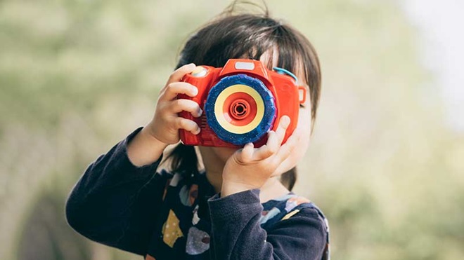 Criança a tirar fotografias com uma máquina infantil.
