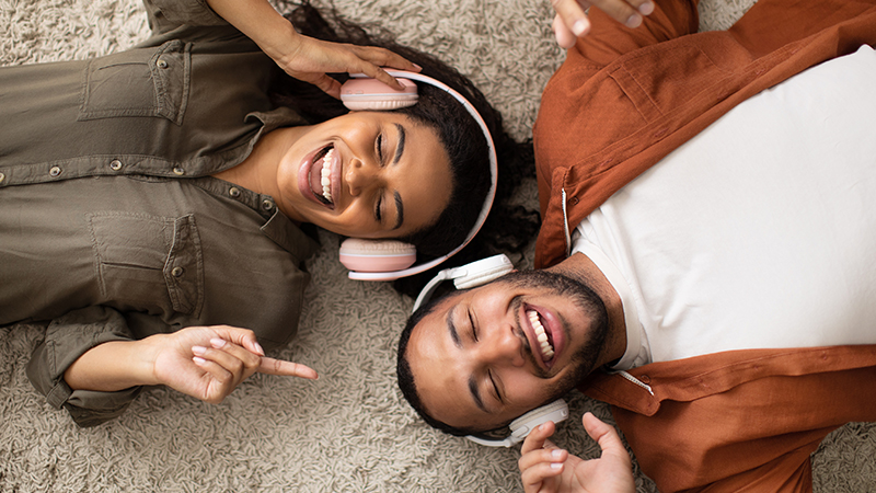 Casal deitado no chão com headphones