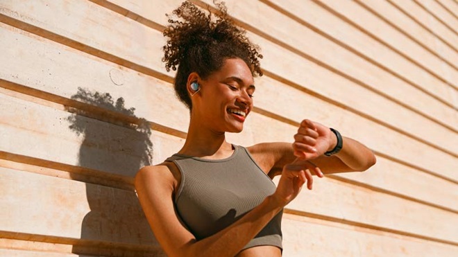 Mulher vestida com roupa desportiva, consulta o smartwatch