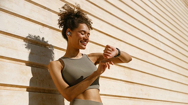 Mulher vestida com roupa desportiva, consulta o smartwatch