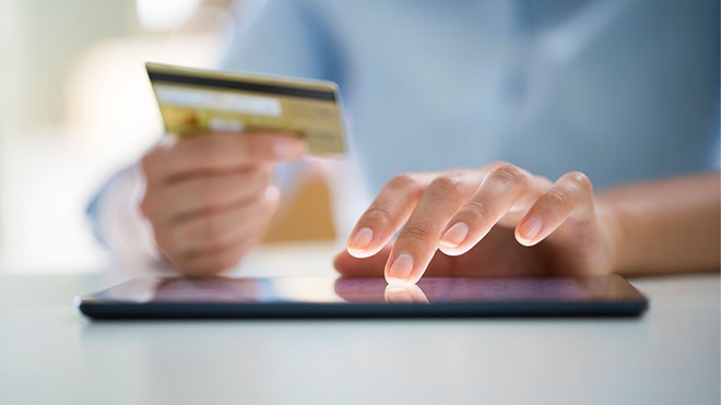 Pessoa a fazer pagamento com cartão bancário através de tablet