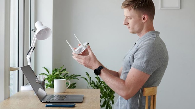 homem na secretária com um router na mão