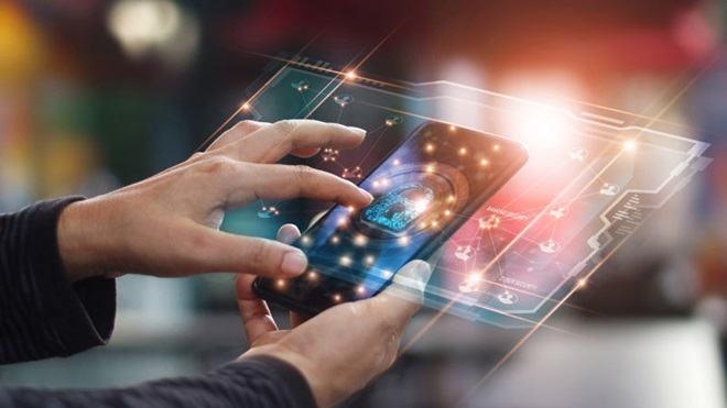 Grande plano de mão a digitar algo num telefone com um símbolo de segurança no écran; fundo tecnológico