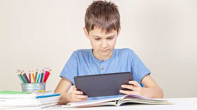 Rapas a estudar com um tablet