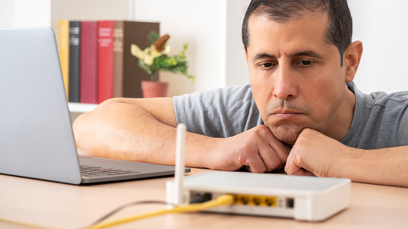Homem a olhar para router com ar ligeiramente zangado
