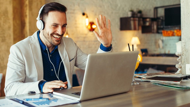 homem ao computador a falar através de videoconferência
