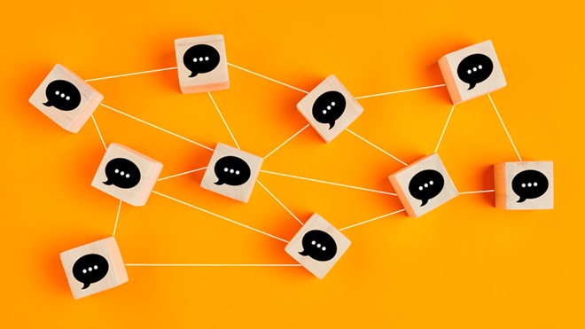 Balões de fala em cubos ligados uns aos outros sobre um fundo amarelo - alusão a redes sociais