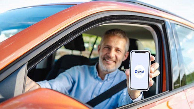 Homem a dentro do carro a mostar a app gov.pt