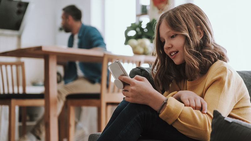 Criança com smartphone perto do pai