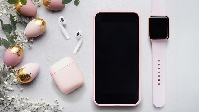 Mesa de Páscoa com pequenos ovos, smartphone, auriculares sem fios e smartwatch