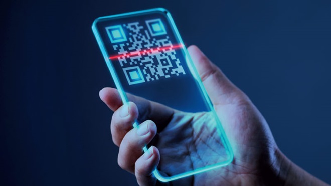 Mão segura um telemóvel transparente com qr code em grande a ser lido - apps de leitura de qr code