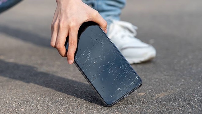 Grande plano de alguém a apanhar um telemóvel que caiu ao chão