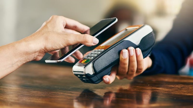 pessoa a pagar com NFC num terminal de multibanco