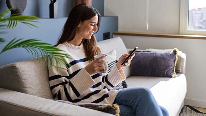 Mulher numa sala com um telemóvel na mão
