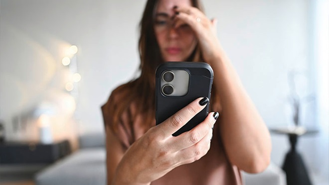 Mulher a olhar para telemóvel smartphone com ar preocupado