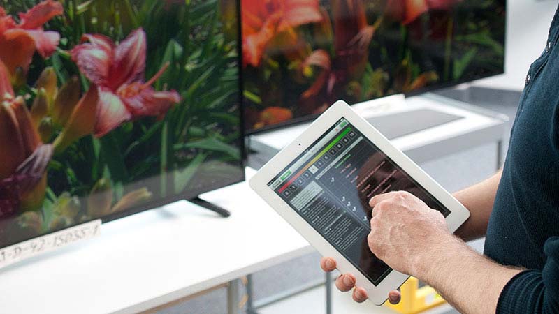 homem com tablet na mão a escolher televisor na loja
