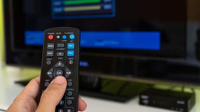 pessoa a sintonizar canais num televisor