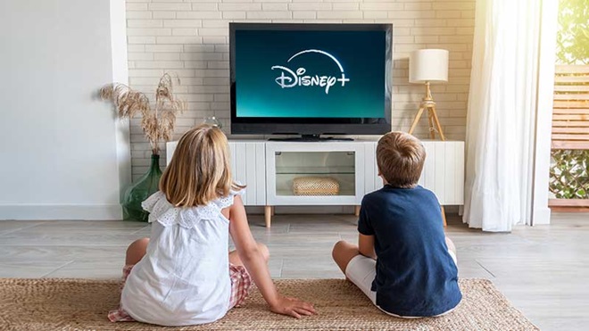 Duas criaças a verem a Disney+ na televisão