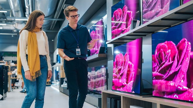 Mulher na loja a ser aconselhada sobre televisores