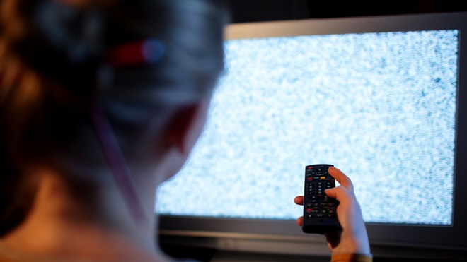 mulher a sintonizar canais da TDT no televisor