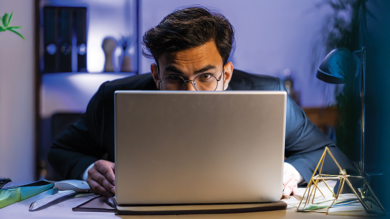 homem ao computador desconfiado