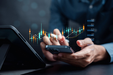 homem a analisar acoes telemovel